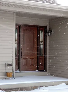 Stained entry door with decorative glass installed in winter, MorningSide yard sign in the snow